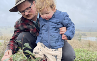Tree planting tips in action as Forestry Australia Director Leon Holt plants a native seedling with his child