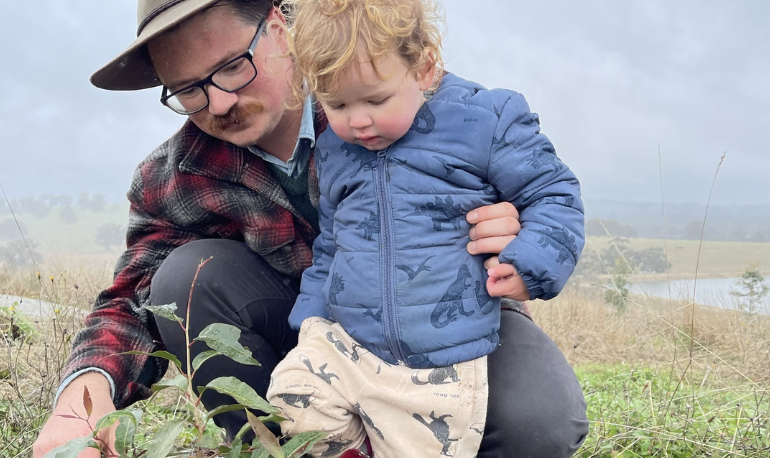 Tree planting tips in action as Forestry Australia Director Leon Holt plants a native seedling with his child