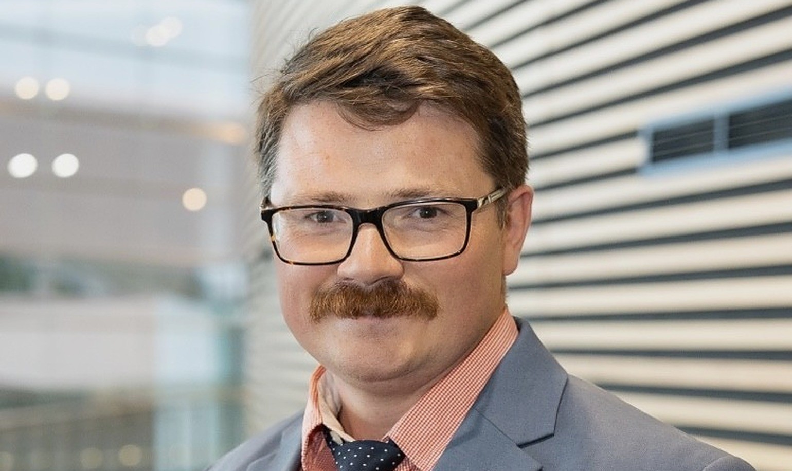 Leon Holt, President of Forestry Australia, wearing glasses, a grey suit and a dotted navy tie