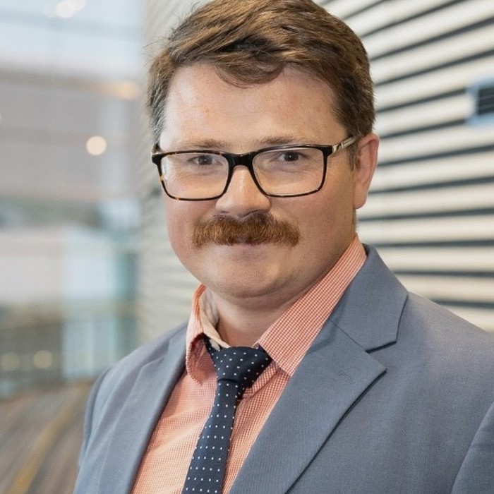 Leon Holt, President of Forestry Australia, wearing glasses, a grey suit and a dotted navy tie